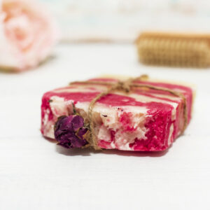 Handmade natural soap with rose on wooden background