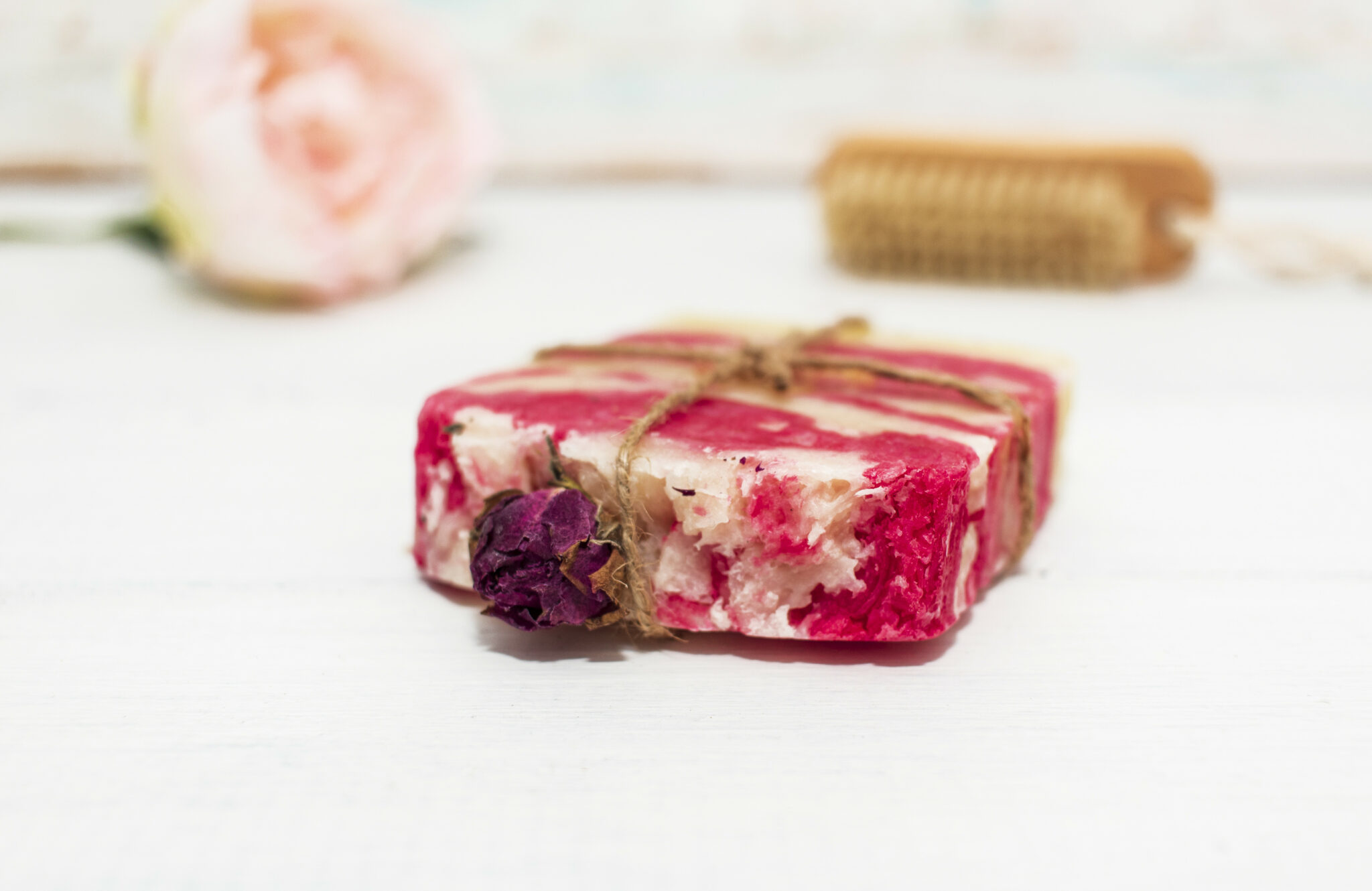 Handmade natural soap with rose on wooden background